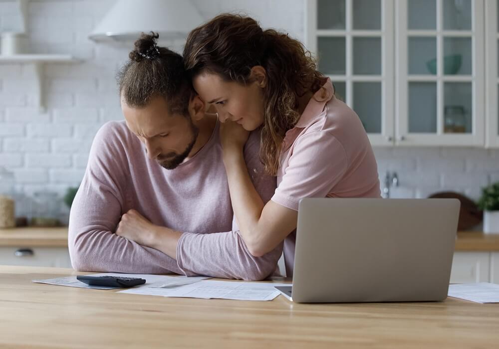 Unhappy young woman supporting stressed husband, feeling depressed having lack of money, suffering from financial problems, planning monthly budget or calculating taxes bills, bankruptcy concept.